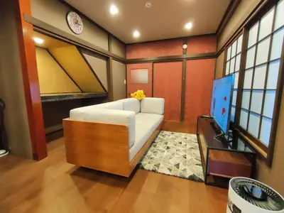 a living room with a white couch and a tv at KIKI HOUSE in Tokyo