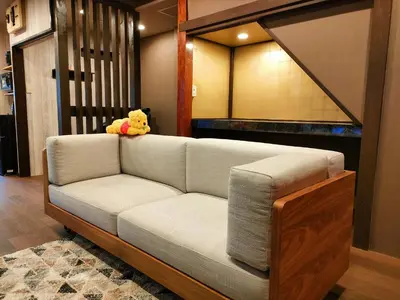 a teddy bear sitting on a couch in a living room at KIKI HOUSE in Tokyo