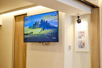 a flat screen tv hanging on a wall at \u65b0\u5bbf\u5e02\u4e2d\u5fc3\u65e5\u5f0f\u6837\u5f0f\u516c\u5bd3\uff0c\u7d27\u90bb\u5546\u4e1a\u5730\u57df\u97e9\u56fd\u8857\u514d\u8d39Wi-Fi in Tokyo