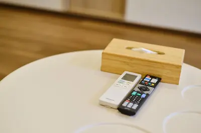 a remote control and a wooden box on a table at \u65b0\u5bbf\u5e02\u4e2d\u5fc3\u65e5\u5f0f\u6837\u5f0f\u516c\u5bd3\uff0c\u7d27\u90bb\u5546\u4e1a\u5730\u57df\u97e9\u56fd\u8857\u514d\u8d39Wi-Fi in Tokyo