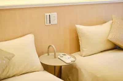 a room with two beds and a remote control on a table at \u65b0\u5bbf\u5e02\u4e2d\u5fc3\u65e5\u5f0f\u6837\u5f0f\u516c\u5bd3\uff0c\u7d27\u90bb\u5546\u4e1a\u5730\u57df\u97e9\u56fd\u8857\u514d\u8d39Wi-Fi in Tokyo