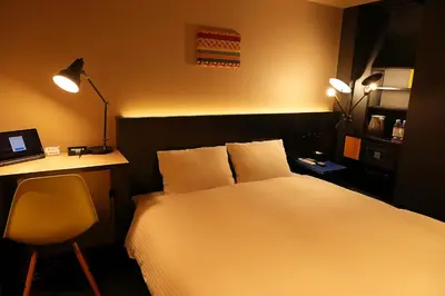 a bedroom with a bed and a desk with a laptop at Nplus HOTEL Higashikanda-akihabara in Tokyo