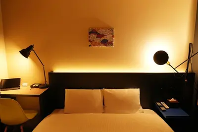 a bedroom with a bed and a desk with a lamp at Nplus HOTEL Higashikanda-akihabara in Tokyo