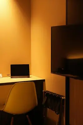 a room with a desk with a laptop and a television at Nplus HOTEL Higashikanda-akihabara in Tokyo