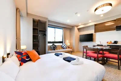 a bedroom with a large white bed and a dining room at ENT TERRACE AKIHABARA in Tokyo