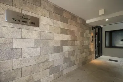 a stone wall in a building with a sign on it at \u30bf\u30b9\u30adsmart\u66d9\u6a4b in Tokyo