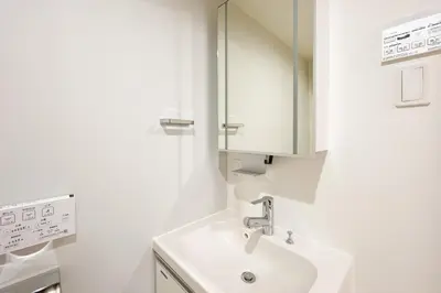 a white bathroom with a sink and a mirror at \u30bf\u30b9\u30adsmart\u66d9\u6a4b in Tokyo