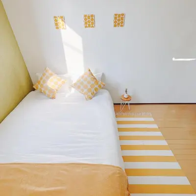 a bedroom with a white bed with orange and white pillows at \u5c0f\u6625\u65e5\u548c_SOLAMO_\u5fae\u751c\u9928 in Tokyo