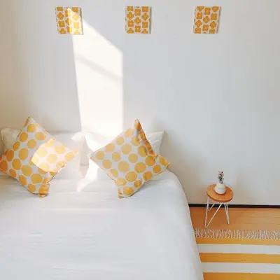 a bedroom with a bed with yellow and white pillows at \u5c0f\u6625\u65e5\u548c_SOLAMO_\u5fae\u751c\u9928 in Tokyo