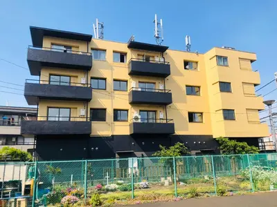 a yellow building with balconies on the side of it at \u532f\u91d1\u5317\u6c60\u888b\u30d3\u30eb in Tokyo