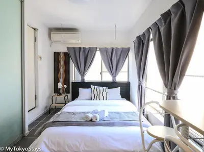 a bedroom with a bed with a teddy bear on it at NEW Heart of Shibuya Prime Studio, Kamiyama Inn! in Tokyo