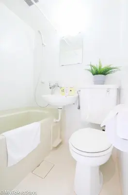 a white bathroom with a toilet and a sink at NEW Heart of Shibuya Prime Studio, Kamiyama Inn! in Tokyo
