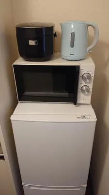a microwave and a slow cooker on top of a refrigerator at JING HOUSE渋谷ダブルベッド/新宿・渋谷駅近 in Tokyo