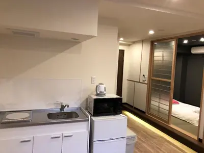 a small kitchen with a sink and a microwave at ohayo\u62bc\u4e0a in Tokyo