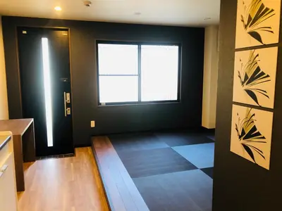 a hallway with a black door and a window at ohayo\u62bc\u4e0a in Tokyo