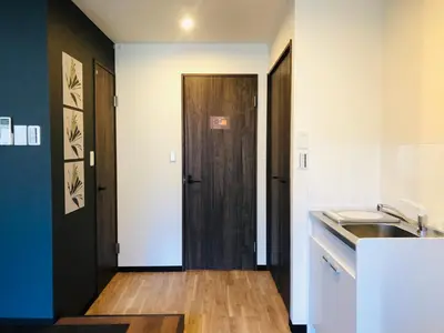 a kitchen with a wooden door and a sink at ohayo\u62bc\u4e0a in Tokyo
