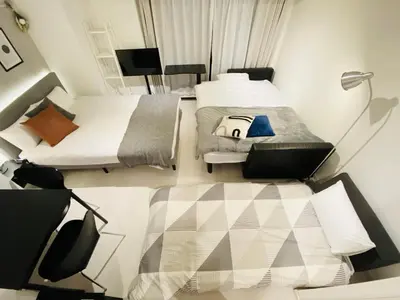 a room with two beds and a lamp in it at FLOWER TERRACE Higashi Shinjuku in Tokyo
