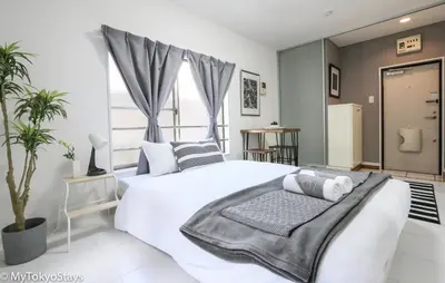 a bedroom with a white bed and a large window at NEW! Relaxing Prime Unit in the Heart of Shibuya! in Tokyo