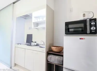 a kitchen with a microwave on top of a refrigerator at NEW!Shibuya Prime Unit, near Shibuya Sky & Hachiko in Tokyo
