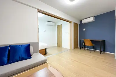 a bedroom with a couch and a table in a room at \u30bf\u30b9\u30adsmart\u6771\u4e2d\u91ce in Tokyo