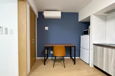 a small kitchen with a table and a yellow chair at \u30bf\u30b9\u30adsmart\u6771\u4e2d\u91ce in Tokyo