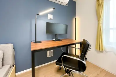 a desk with a monitor and a chair in a room at \u30bf\u30b9\u30adsmart\u6771\u4e2d\u91ce in Tokyo