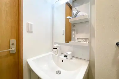 a bathroom with a white sink and a mirror at \u30bf\u30b9\u30adsmart\u6771\u4e2d\u91ce in Tokyo