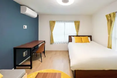 a bedroom with a bed and a desk and a window at \u30bf\u30b9\u30adsmart\u6771\u4e2d\u91ce in Tokyo