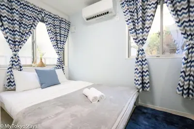 a bedroom with a bed with blue and white curtains at Skytree Easy Access Tokyo Apartment - Bell Flat Inn #1 in Tokyo