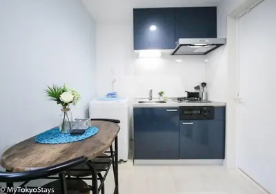 a small kitchen with a wooden table and a sink at Skytree Easy Access Tokyo Apartment - Bell Flat Inn #1 in Tokyo