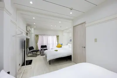 a hotel room with two beds and a desk at LUANAHOTEL IN YOTSUYA in Tokyo