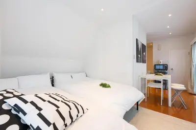 a bedroom with a white bed and a desk at LUANAHOTEL IN YOTSUYA in Tokyo