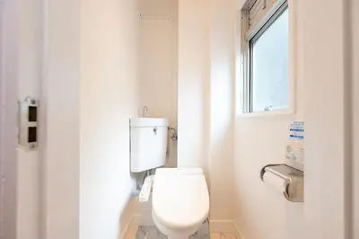 a white toilet in a bathroom with a window at LUANAHOTEL IN YOTSUYA in Tokyo