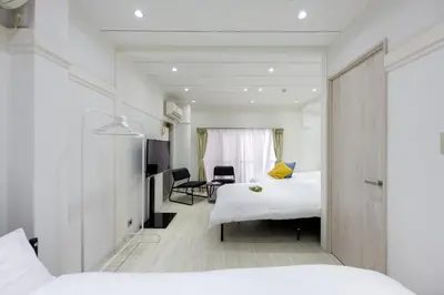 a hotel room with two beds and a desk at LUANAHOTEL IN YOTSUYA in Tokyo
