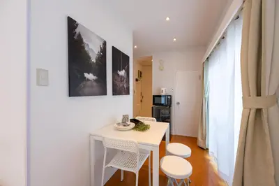 a small dining room with a white table and chairs at LUANAHOTEL IN YOTSUYA in Tokyo
