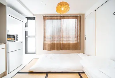 a small bedroom with a bed and a window at Ustay Nippori in Tokyo