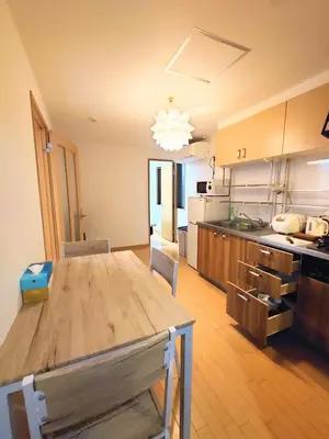 a large kitchen with a wooden table in a room at kaneshiro guest house in Tokyo