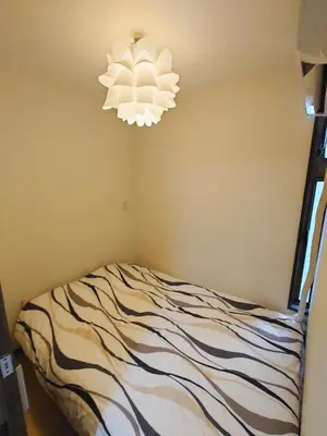 a bedroom with a bed and a chandelier at kaneshiro guest house in Tokyo