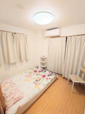 a small bedroom with a bed and a chair at kaneshiro guest house in Tokyo