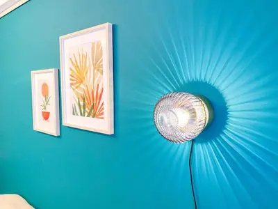 a blue wall with two pictures and a lamp on it at Al Di La \u56db\u8c37 in Tokyo