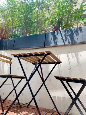a wooden table and two chairs next to a wall at Ken's Place四谷 in Tokyo