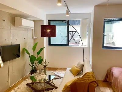 a living room with a couch and a tv at Ken's Place四谷 in Tokyo