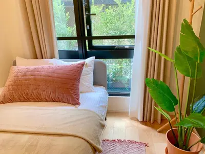 a room with a bed and a window with a plant at Ken's Place四谷 in Tokyo