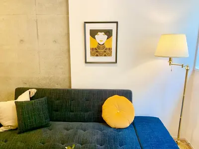 a living room with a green couch and a lamp at Ken's Place四谷 in Tokyo