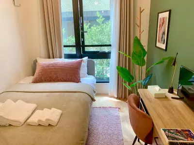 a bedroom with a bed and a desk and a window at Ken's Place四谷 in Tokyo