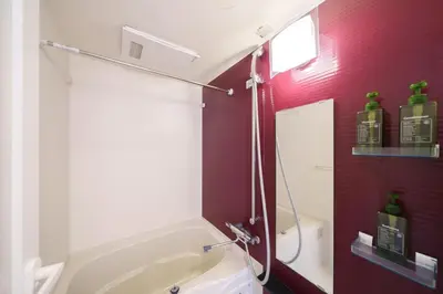 a bathroom with a white tub and a red wall at Space Roppongi in Tokyo