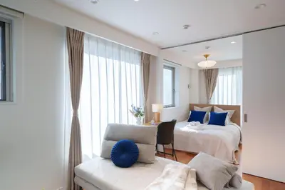 a bedroom with a bed and a chair and a mirror at Space Roppongi in Tokyo