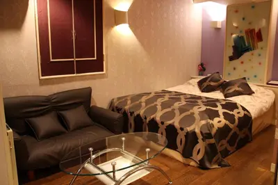 a bedroom with a bed and a couch and a glass table at SKYROAD Adult Only in Tokyo