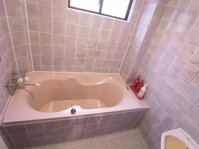 a bath tub in a tiled bathroom with a toilet at SKYROAD Adult Only in Tokyo