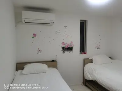 two beds in a room with flowers on the wall at \u5c71\u624b\u7dda\u7530\u7aef\u99c5\u304b\u3089\u5f92\u6b695\u5206\u3001\u3068\u3066\u3082\u4fbf\u5229\u306a\u5834\u6240\u3067\u3059 in Tokyo